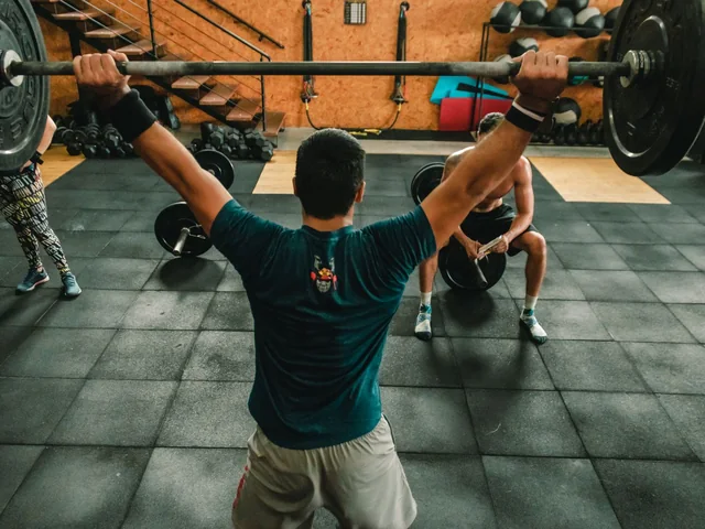 Fitness instruktor súlyzós edzést vezet a fitneszteremben